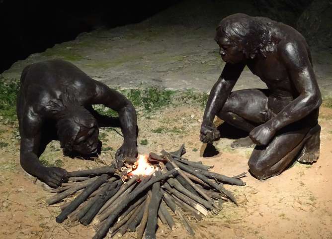 древние люди разжигают огонь