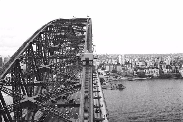 Australia-New-South-Wales-Sydney-Harbour-Bridge-steelwork-beams-open-construction-rivets-box-girders-curve-of-span-visible-steps-with-visitors-tourists-walking-down-mono-3-MB