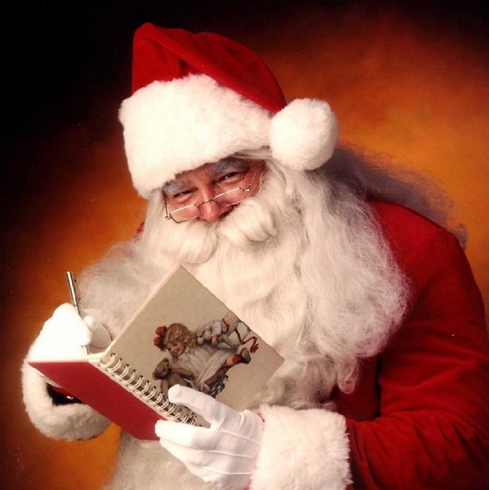 Санта Клаус с подарками на фоне елки