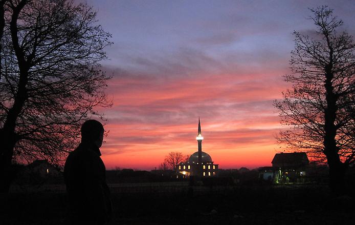 силуэт человека на фоне мечети в праздничный день
