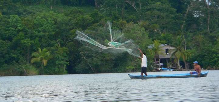 Река Рио-Дульсе в Гватемале с лодкой и джунглями