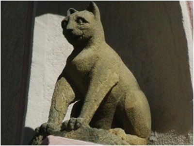 Каменная фигура кота на фасаде церкви во Франции